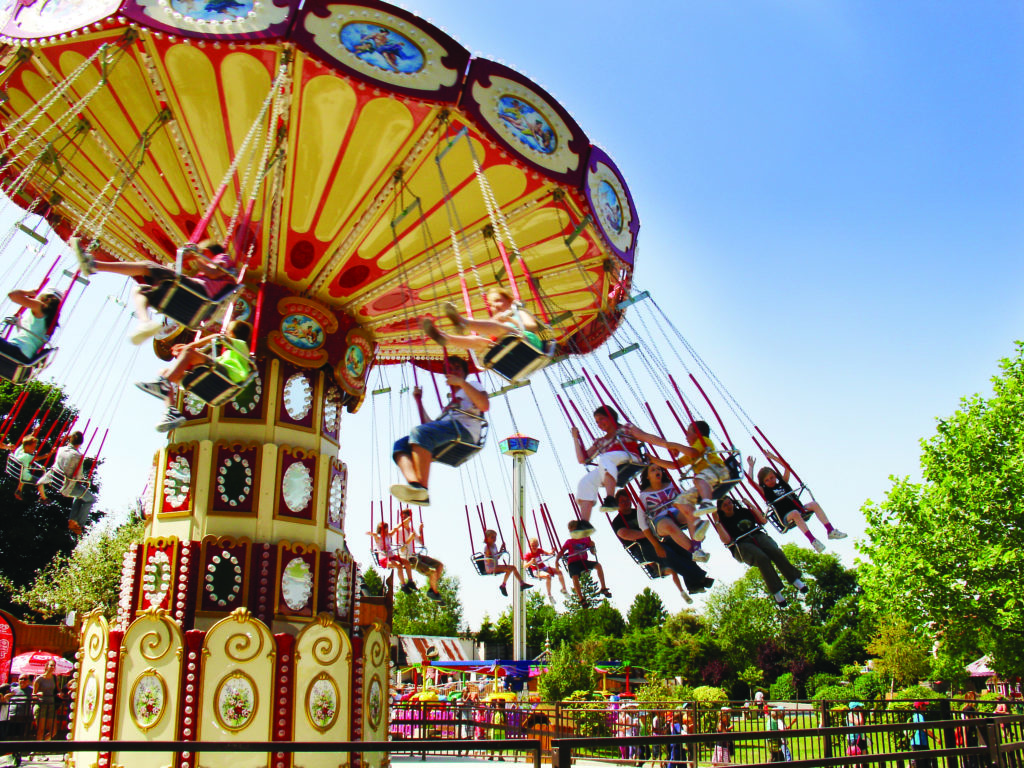 Niños en un tiovivo con sillas voladoras en Dennlys Parc.